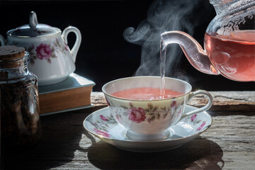 a cup of tea on a wooden table,process brewing tea,Cup of freshly brewed fruit and herbal tea,...
