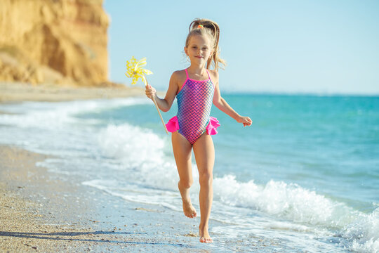 Child at sea. Children's fashion. Child in a swimsuit on the beach. High quality photo.