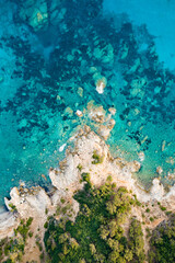 Fototapeta na wymiar View from above, stunning aerial view of a green and rocky coastline bathed by a turquoise, crystal clear water. Costa Smeralda, Sardinia, Italy.