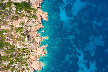 View from above, stunning aerial view of a green and rocky coastline bathed by a turquoise, crystal clear water.Sardinia, Italy.