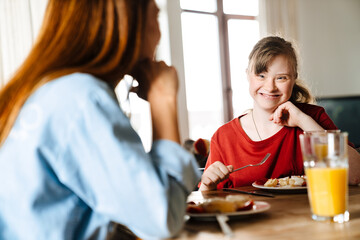 White woman and her daughter with down syndrome having breakfast