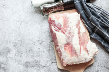 Piece of raw pork on a gray background. Fresh meat is ready to cook. view from above