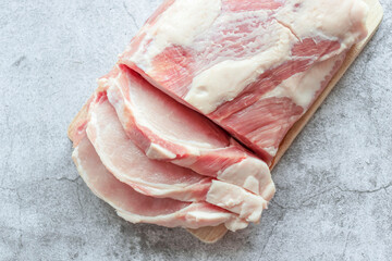 Piece of raw pork on a gray background. Fresh meat is ready to cook. view from above