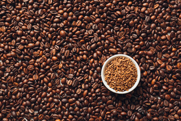 Bowl with instant coffee and beans as background. Concept of uniqueness