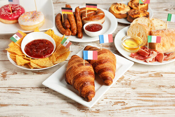 Plates with traditional food of different countries on wooden background
