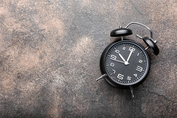 Stylish alarm clock on grunge background