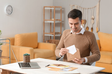 Young man with letter at home