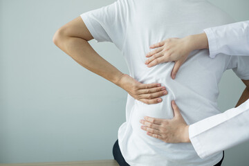 Female physiotherapists provide physical assistance to male patients with back injuries back massages for relaxation and muscle recovery in the rehabilitation center
