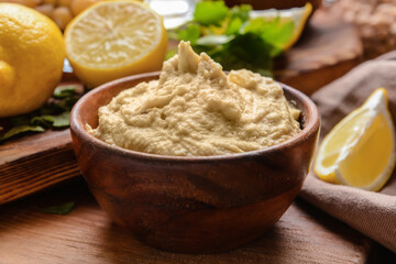 Bowl with tasty hummus on table, closeup