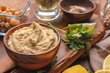 Bowl with tasty hummus on table