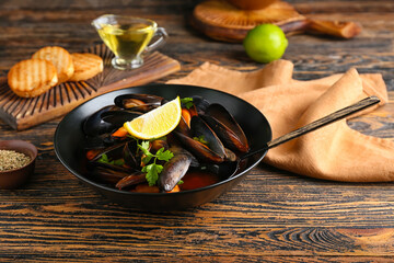 Plate with tasty Mussels Marinara on wooden background