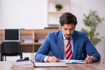 Fototapeta premium Young male employee sitting at workplace