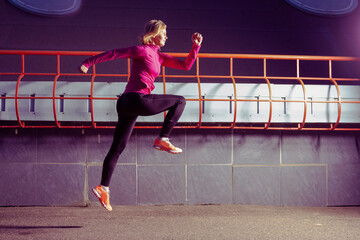 Fototapeta na wymiar Mature Female Runner in Jogging Outfit During Running Training in Evening City Environment.