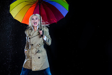 Portrait of Smiling Caucasian Blond Female Jumping with Colorful Umbrella Under The Multiple Water Droplets.