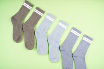 Set of warm socks in gray shades on a pistachio-colored background