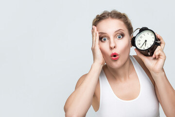 Lifestyle Concepts. Young Stressfull Caucasian Female With Alarm Clock And Lifted Hand on Face.