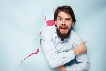 man in blue shirt peeking out of the background office close-up