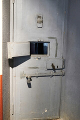 Prison cell iron door with observation window and steel bolts - 453749295