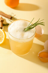 Glass of tasty whiskey sour cocktail on color background