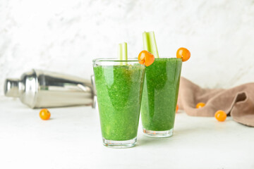 Glasses of bloody Mary cocktail on light background