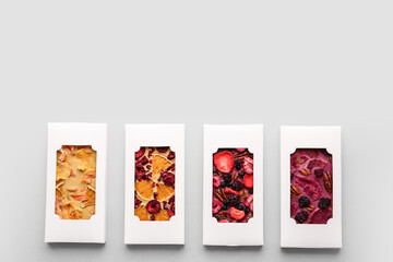 Handmade chocolate bars with fruits and berries on light background
