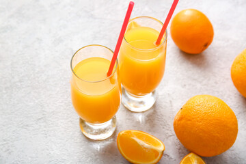 Glasses of tasty orange juice on light background, closeup