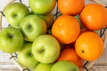 green apples and tangerines, oranges on the table close-up, fruit background, healthy food concept