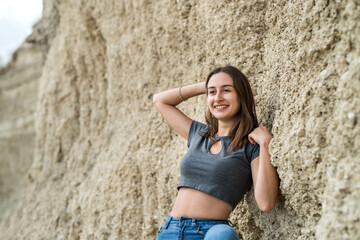Pretty woman in casual clothes poses in sand canyon, relax at nature in summer time