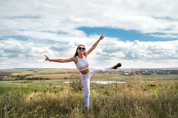 Fototapeta premium girl in casual cloth in a rural green field goes in summer