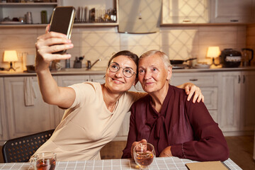 Aged lady and young woman taking a picture together