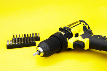 The yellow-black screwdriver on a yellow background, a set of bits.