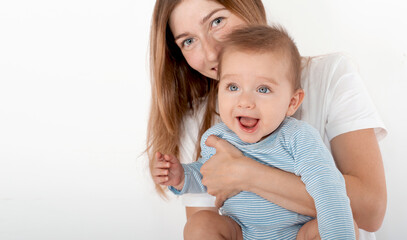 Mother holding cute happy baby boy with beautiful blue eyes on white background