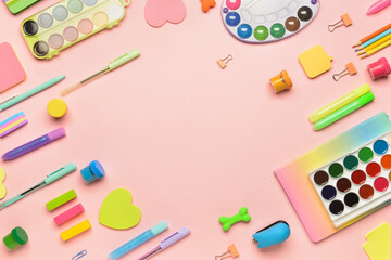 Frame made of stationery supplies on color background