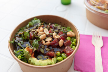 take-away poke bowl with beans, tuna fish, avocado and vegetables, to-go vegetarian bowl 