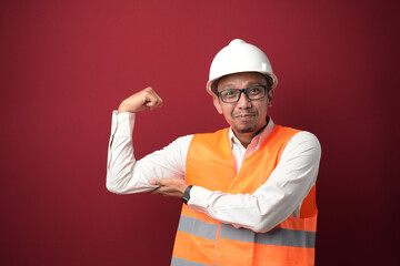 Young Asian worker wearing helmet strong person showing arm muscle confident and proud of power