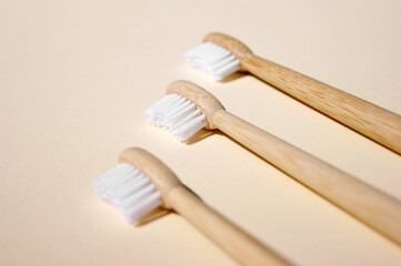 Fototapeta na wymiar Three natural bamboo toothbrushes on light background.
