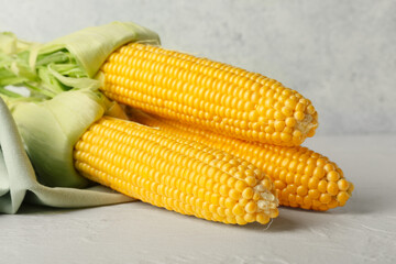 Fresh corn cobs on light background