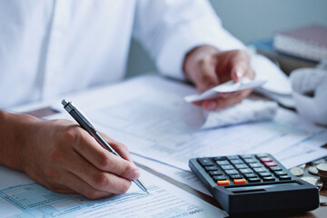 Naklejka premium Man hand filling US tax form. tax form us business income office Financial document. Tax time.Tax concept. Close-up.