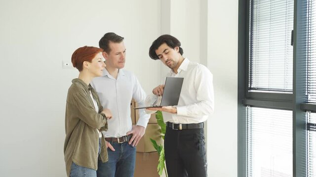 Real estate broker agents advise clients to make decision to buy house with insurance showing it on laptop. Negotiating purchase-sale and investment planning concept.