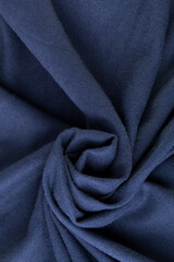 Wool textile blue colored. Texture of fabric. A rose flower spiral shape
