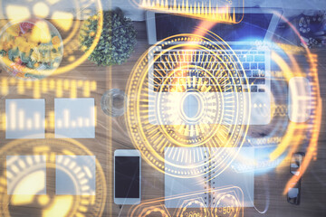Technology hologram drawing over computer on the desktop background. Top view. Double exposure. Tech concept.
