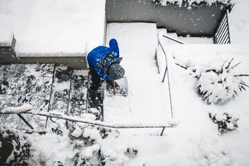 man shovelling and clear the snow, winter work on premises with snow pusher