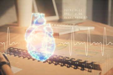 Double exposure of heart drawing and desk with open notebook background. Concept of medical education