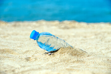 Fototapeta na wymiar A bottle of drinking water on the sea beach 