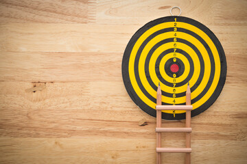Pencil ladder and dartboard with wooden background. Education or business growth for successful...