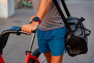 Unrecognizable young man with bicycle in the street