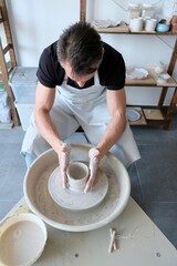 Pottery workshop, man potter makes a pitcher out of clay, handicraft, production of handmade tableware.