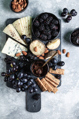 Different types of cheese with fruits, berries, nuts and bread.