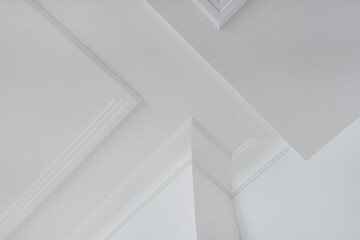 Detail of corner ceiling and walls with intricate crown moulding. Interior construction and renovation concept.