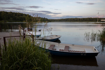 Obraz premium Landscape with boats at the pier. Boats on the banks of the river. Evening landscape.
